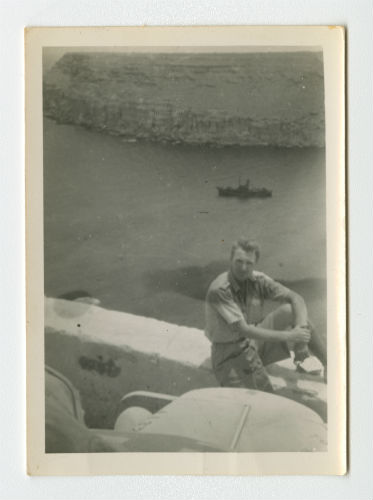 Dave Hyatt in Bardia, Libya with a ship in the background. Recto