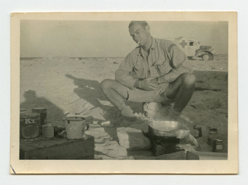 Arthur Howe, Jr. preparing food in the desert. Recto