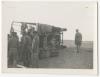Men standing near an overturned vehicle