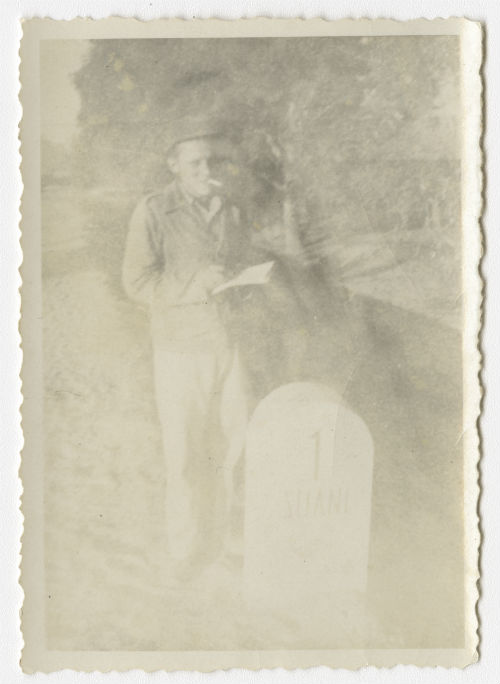 Unidentified individual standing near a milestone near Al-Swani, Libya