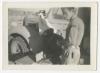 Two unidentified individuals beside an AFS vehicle with 567 Coy insignia