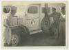 William "Bill" Gosline (hand on tire) and Samuel "Sam" Hobbs observing the new insignia. Recto