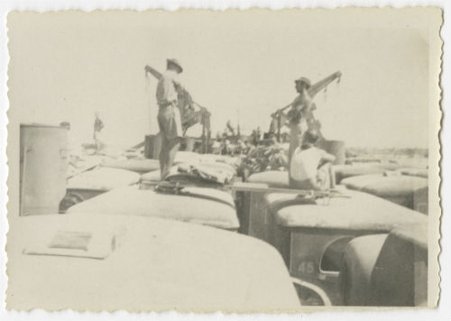 Men on vehicle roofs on the LST to Italy