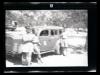 Three individuals by an AFS staff car in Tunisia